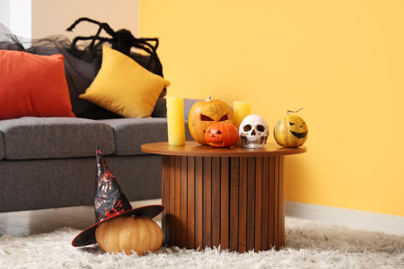 Halloween pumpkins with skull and candles on table in living room interiorの写真素材
