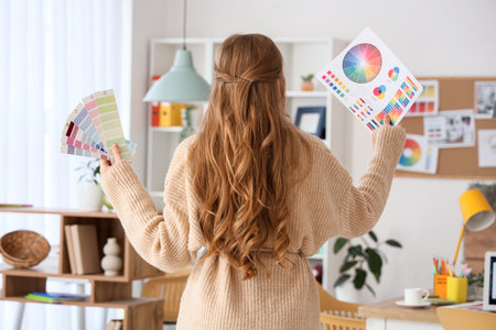 Female web designer with color palettes in office, back viewの写真素材