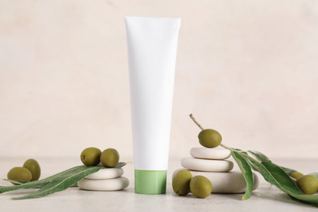 Composition with tube of natural cosmetic product, spa stones and green olives on light backgroundの写真素材