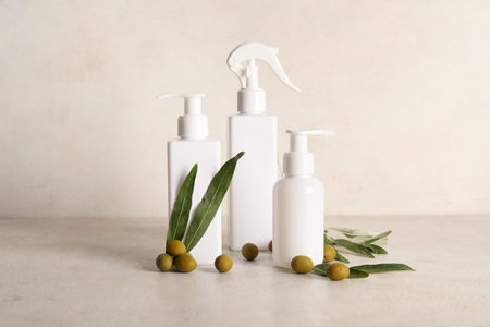 Set of natural cosmetic products and green olives on light background