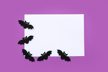 Blank card and Halloween paper bats on purple background, top viewの写真素材