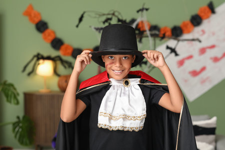 Cute happy African-American boy dressed as Dracula for Halloween party at homeの写真素材