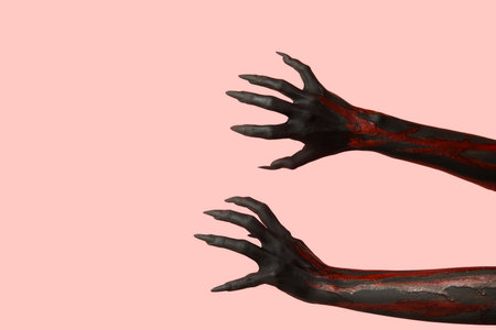 Black witch hands with claws on pink background. Halloween celebrationの写真素材
