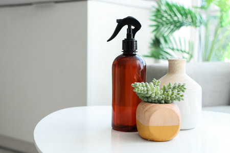 Bottle of aroma spray with plant and vase on table in room, closeupの写真素材