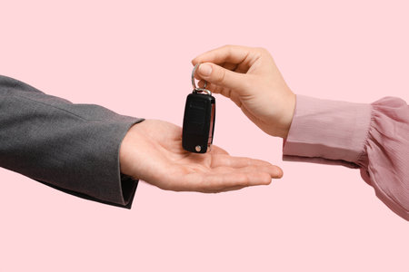 Couple with car key on pink background, closeupの写真素材