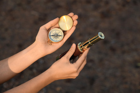 Woman with compass and spyglass in forest, closeupの写真素材