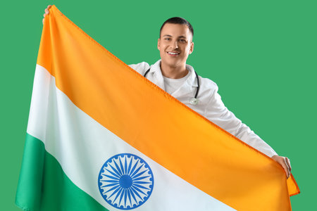 Male doctor with flag of India on green background. National Doctor's Day celebrationの写真素材