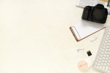 Composition with professional photo camera, modern gadgets and clipboard on light background