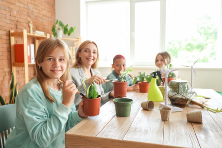 Female teacher and pupils planting during Ecology lesson in classroomの写真素材