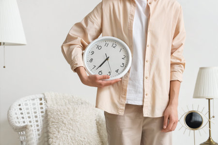 Young woman with clock in living room, closeup
