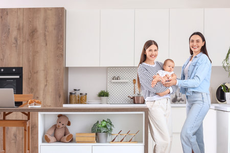 Young lesbian couple with their little baby in kitchenの写真素材