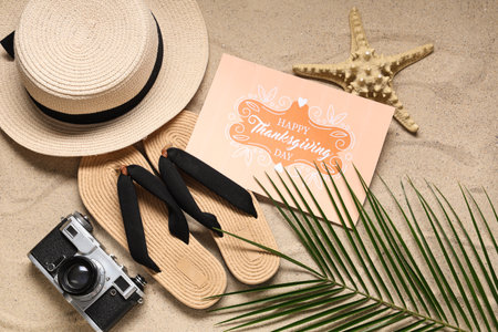 Card for Thanksgiving Day with beach accessories and palm leaf on sand, top viewの写真素材