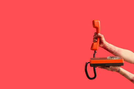 Zombie hands with telephone on red background. Halloween celebrationの写真素材