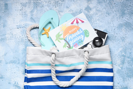 Card for Thanksgiving Day with photo camera, flip-flops and beach bag on grunge background