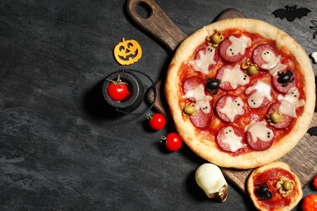 Composition with tasty Halloween pizzas, tomatoes and decorations on dark backgroundの写真素材