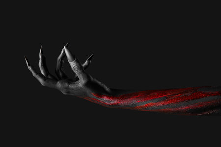 Bloody witch hand with claws on black background. Halloween celebrationの写真素材