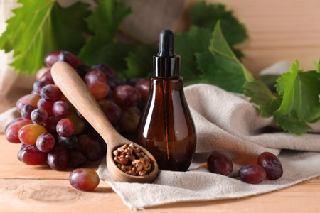 Bottle of cosmetic grape seed oil on wooden backgroundの写真素材