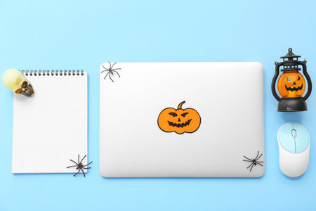 Composition with modern laptop, computer mouse, notebook and decorations for Halloween on color backgroundの写真素材