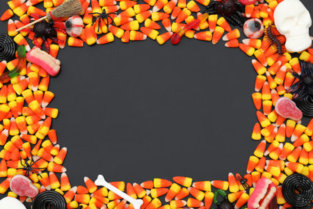 Frame made of different candies and decorations for Halloween on dark backgroundの写真素材