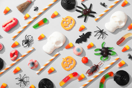 Composition with decorations and different candies for Halloween on gray backgroundの写真素材