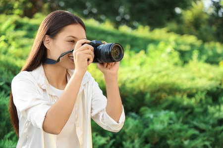 Female photographer with camera in parkの写真素材