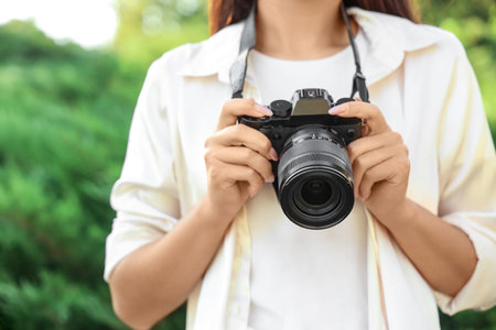 Female photographer with camera in park, closeupの写真素材