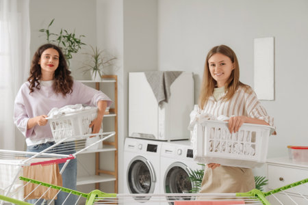 Female students with laundry baskets in dormitoryの写真素材