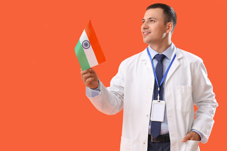 Male physician with flag of India on orange background. National Doctor's Day celebrationの写真素材