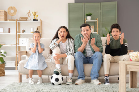 Shocked family upset with results of football game at homeの写真素材