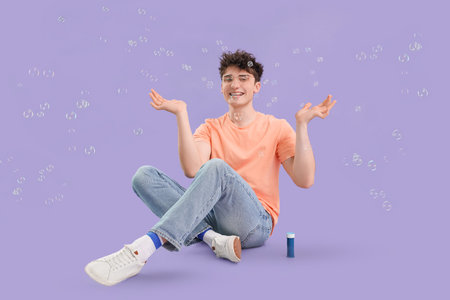 Young man with soap bubbles on lilac background