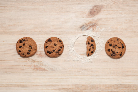 Sweet cookies with chocolate chips on wooden background