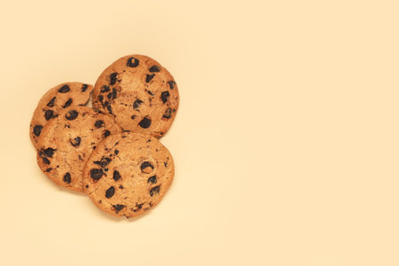Sweet cookies with chocolate chips on beige backgroundの写真素材