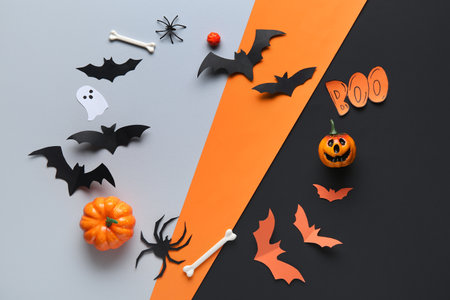 Frame made of paper bats with word BOO, spiders, bones and pumpkins for Halloween party on colorful backgroundの写真素材