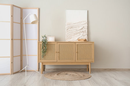 Folding screen and home decor on commode near white wallの写真素材