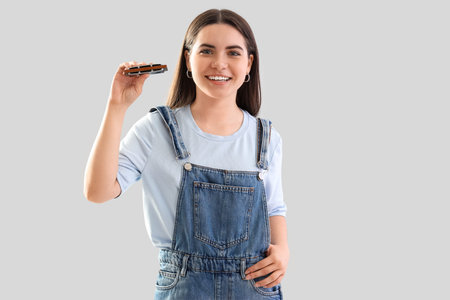 Young woman with harmonica on light backgroundの写真素材