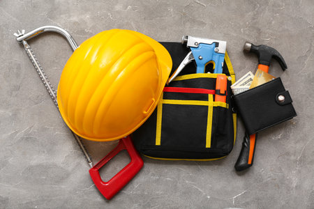 Composition with hardhat, construction tools, wallet and money on grunge backgroundの写真素材