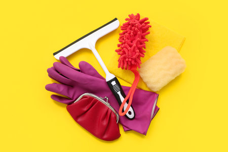 Composition with cleaning supplies and wallet on yellow backgroundの写真素材
