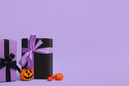 Halloween gift boxes with decorative pumpkins on purple backgroundの写真素材