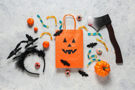 Shopping bag with Halloween headband, ax and candies on grunge white backgroundの写真素材