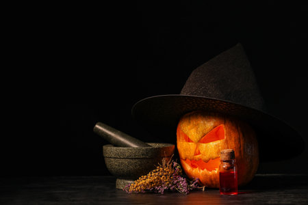 Halloween composition with jack-o-lantern in witch hat, mortar, flowers and bottle of poison on...