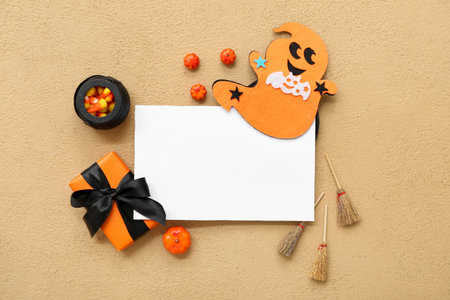 Composition with blank card, candy corns, decorations and gift for Halloween on color backgroundの写真素材