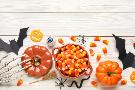 Halloween composition with toys and candies on white wooden background