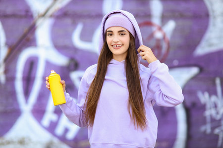 Teenage girl with spray paint outdoorsの写真素材