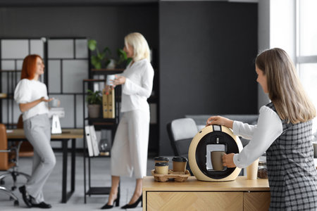 Young woman making coffee in office