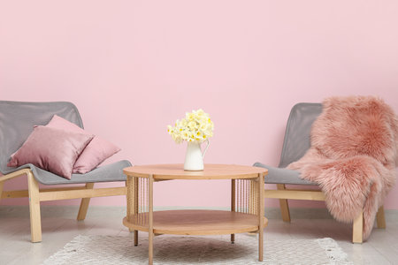 Vase with beautiful narcissus in interior of living roomの写真素材