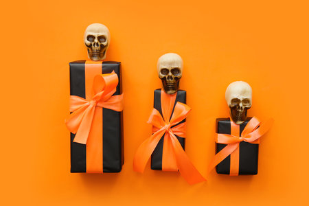 Halloween gifts and skulls on orange background. Top viewの写真素材