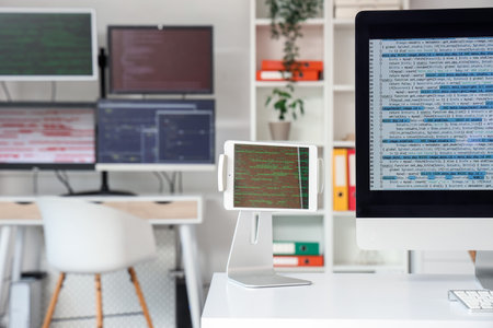 Tablet computer with code on programmer's desk in office, closeupの写真素材
