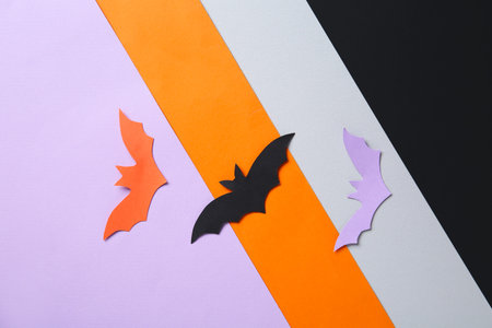 Paper bats for Halloween party on colorful background
