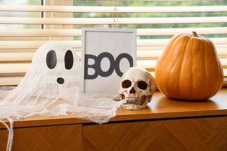 Chest of drawers in stylish living room decorated for Halloween with ghost, skull and pumpkinの写真素材