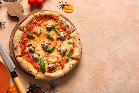 Wooden board of tasty pizza with mushrooms and spiders for Halloween celebration on beige backgroundの写真素材